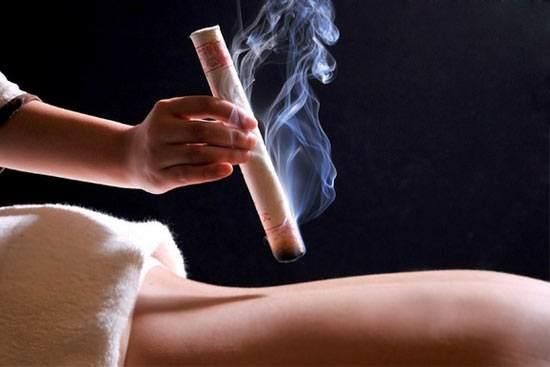 Massothérapeute usant le Moxa sur son client